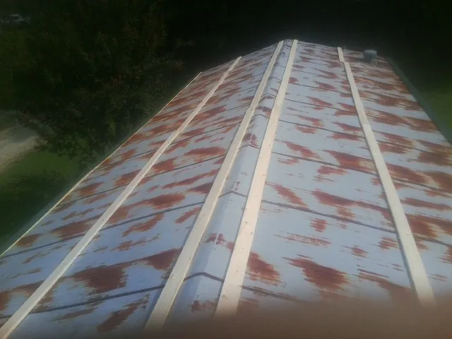 Rusted metal roof panels with new wood purlins before replacement — Storm Damage Roof Repair in Sumner by Roofing Brothers