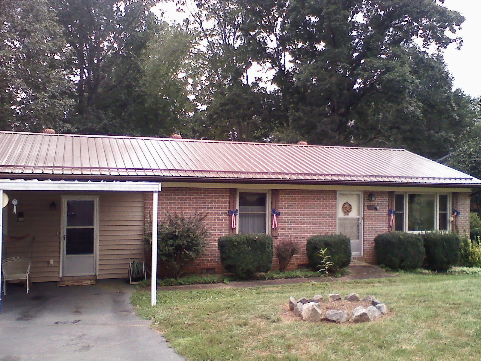 Bronze metal roof and carport on a brick ranch home — Roof Repair work by our crew in Sumner